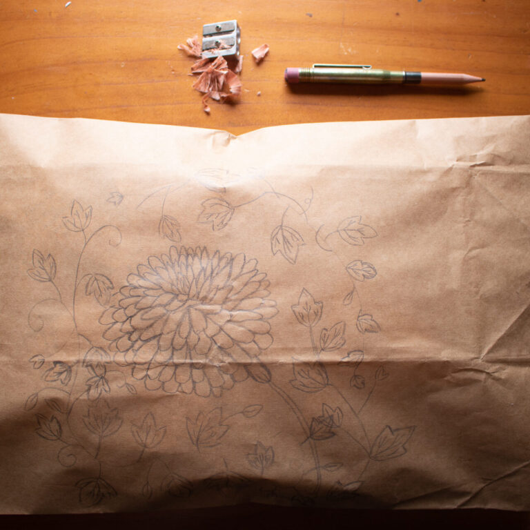 Brown paper package with ivy and chrysanthemum pencilled on it.